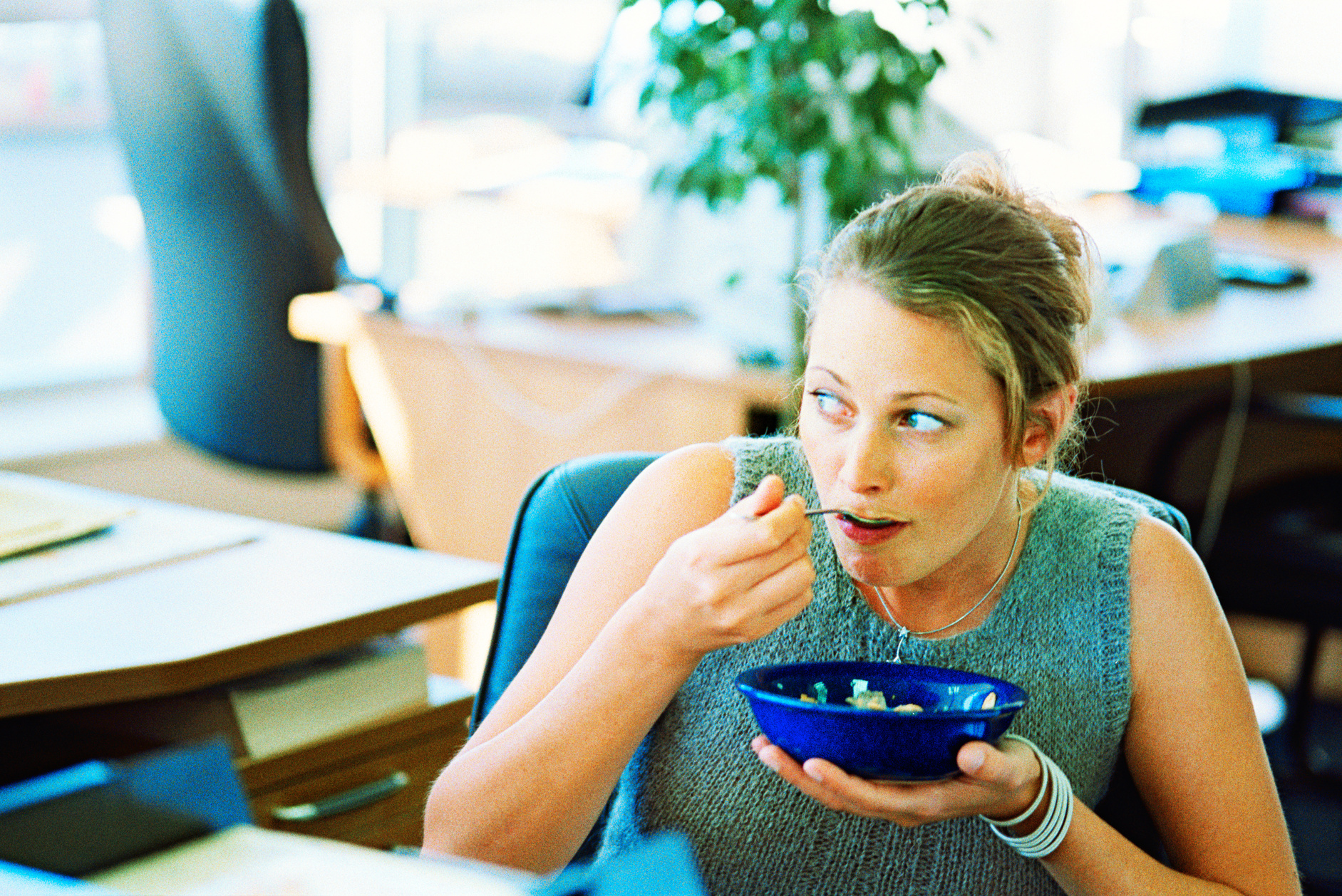 close-up of a woman eating soup watchfully